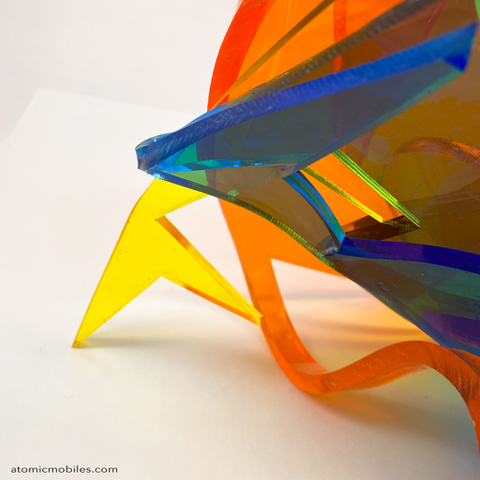 Closeup view of Dream Abstract Art Sculpture from the Sculptura Collection of incredibly unique art sculptures hand made with earth-friendly upcycled acrylic plexiglass by Debra Ann of AtomicMobiles.com in Los Angeles, featuring bold colors of clear orange, clear blue, and clear yellow