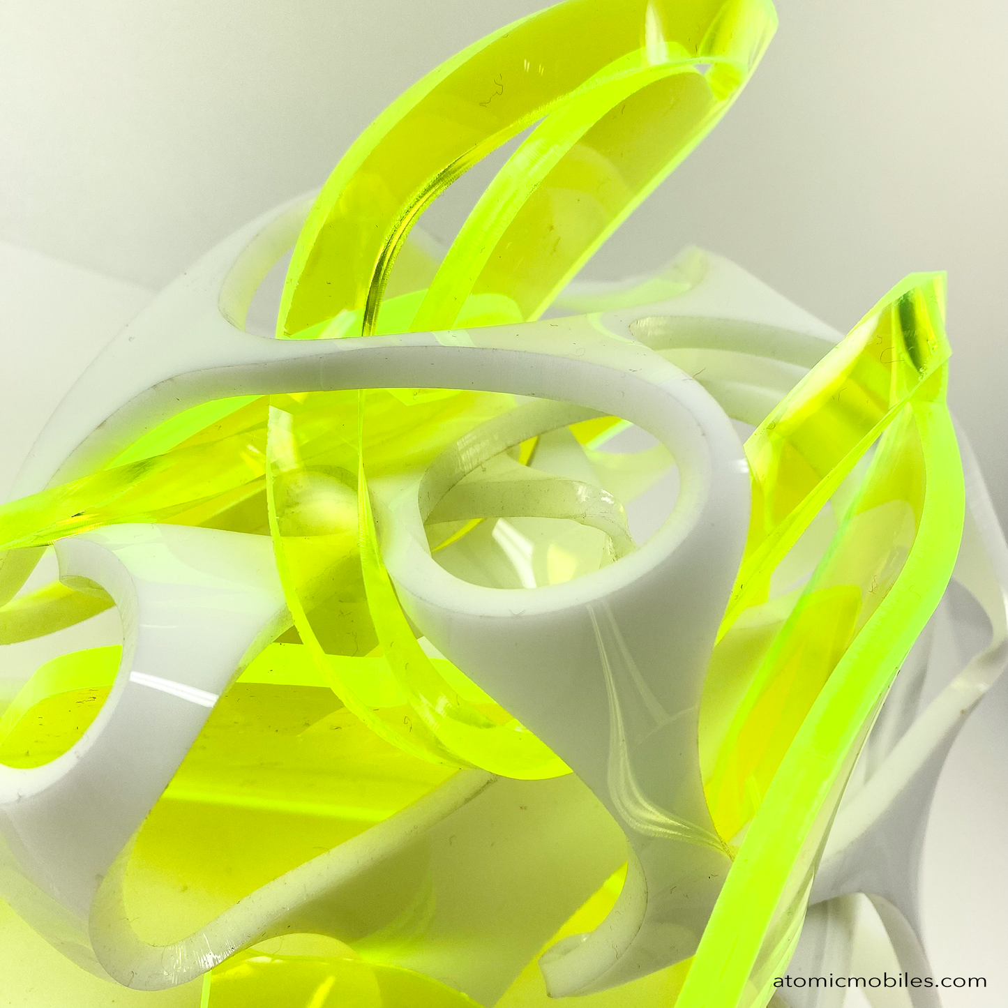 Closeup of top of Thrill abstract art sculpture in neon fluorescent green and opaque white acrylic plexiglass - upcycled and recycled acrylic one-of-a-kind modern art by Debra Ann of AtomicMobiles.com in Los Angeles