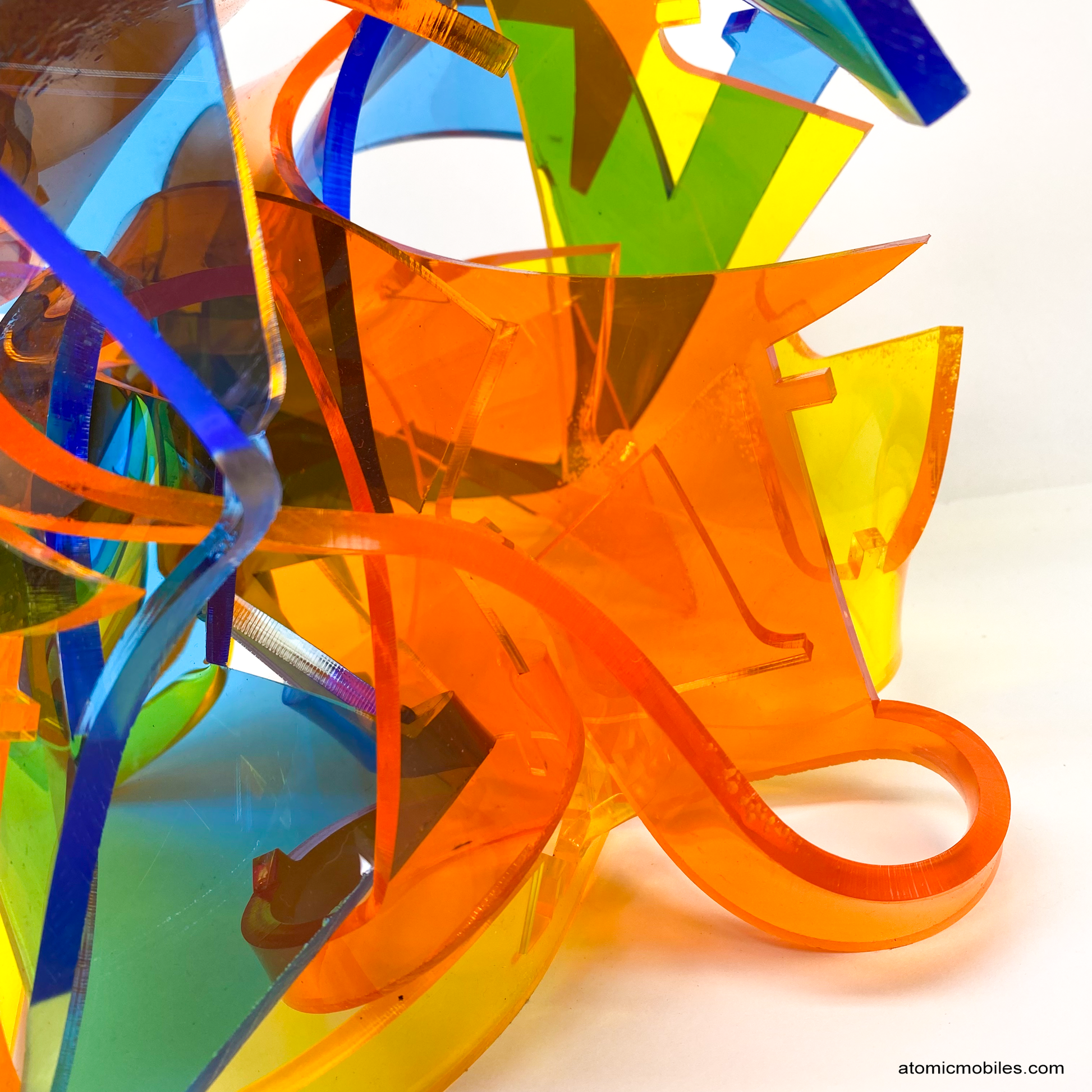 Closeup of mesmerizing Euphoria colorful abstract plexiglass acrylic abstract art sculpture in tranparent orange, yellow, blue - one of a kind modern art by AtomicMobiles.com