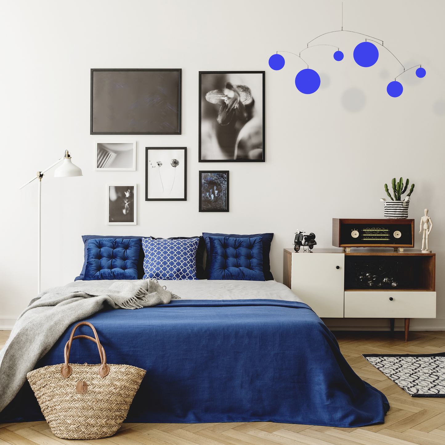 Beautiful boho blue bedroom with black and white framed photos, stereo, and wood floor with Exhilaration Sapphire Blue kinetic art mobile by AtomicMobiles.com