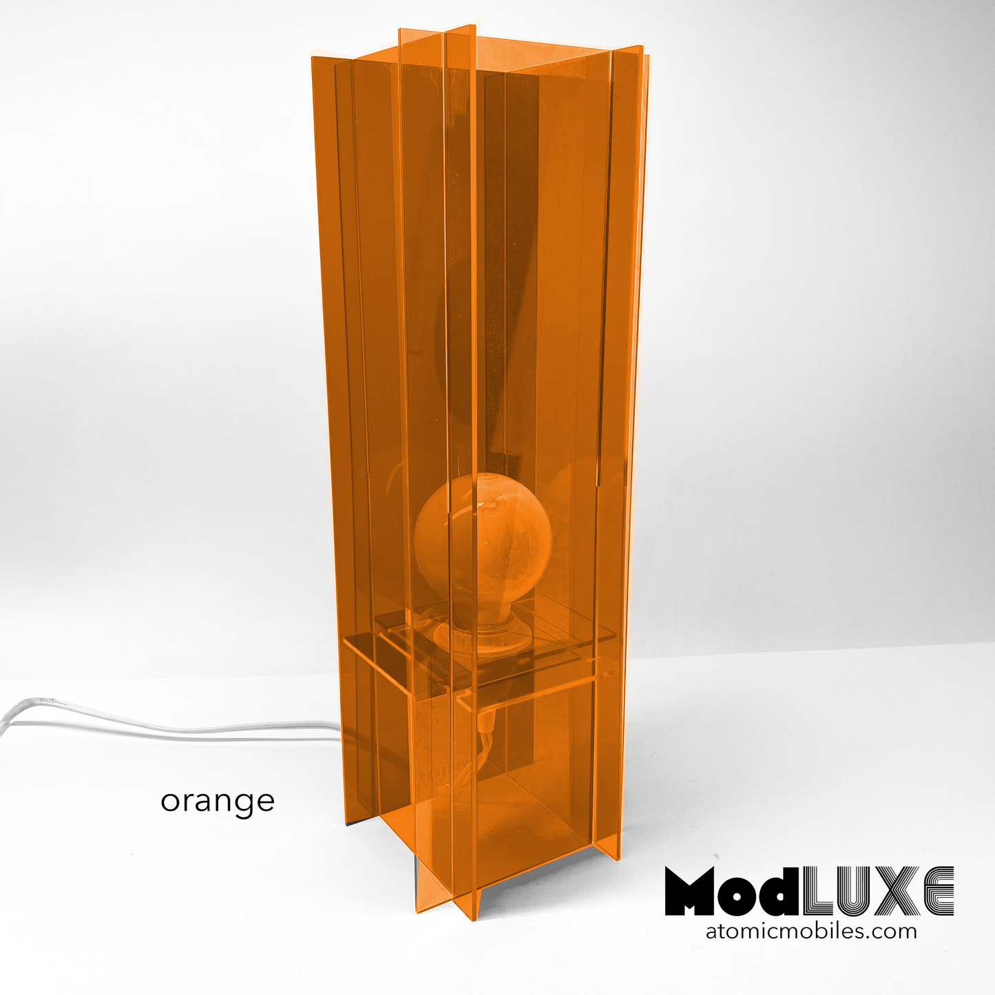 ModLuxe in mod 1970s transparent orange acrylic. Retro groovy space age table lamp for modern home decor made by AtomicMobiles.com