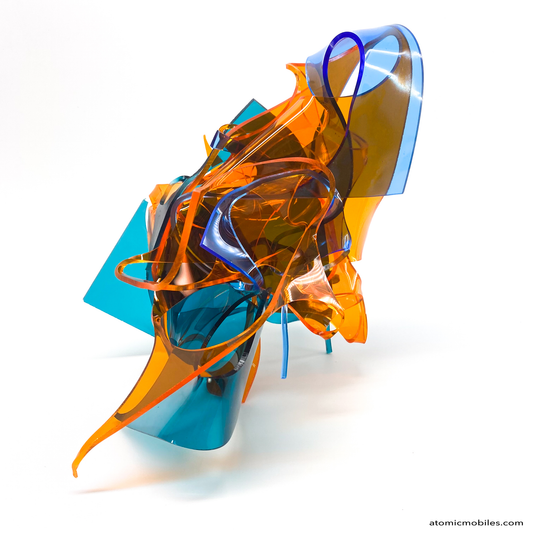 Side view of Colorful abstract sculpture in transparent orange, teal, and blue plexiglass acrylic on a white background titled Radiance of Water - one of a kind art by Debra Ann of Atomic Mobiles