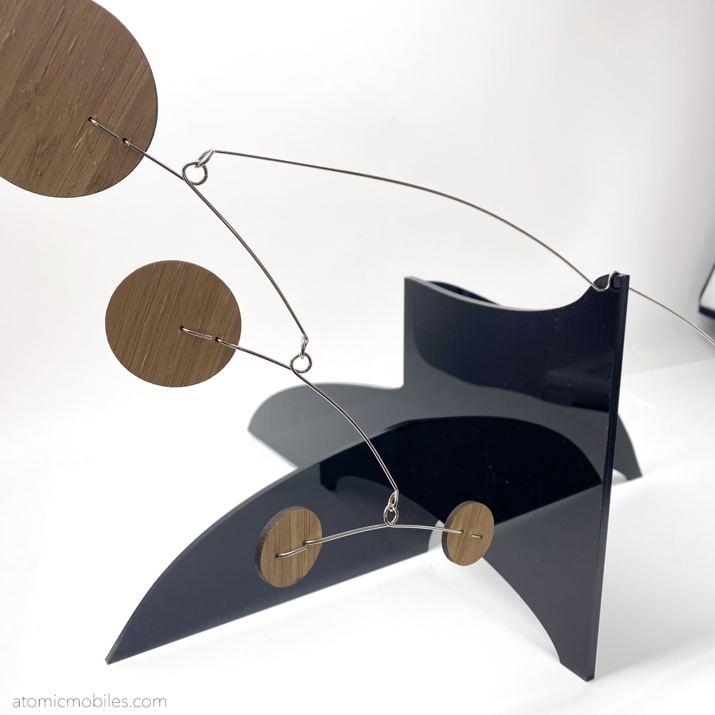SIde view of The Moderne Elegant Kinetic Art Stabile Sculpture with glossy black acrylic plexiglass base and bamboo wood shapes - custom made art in Los Angeles by AtomicMobiles.com