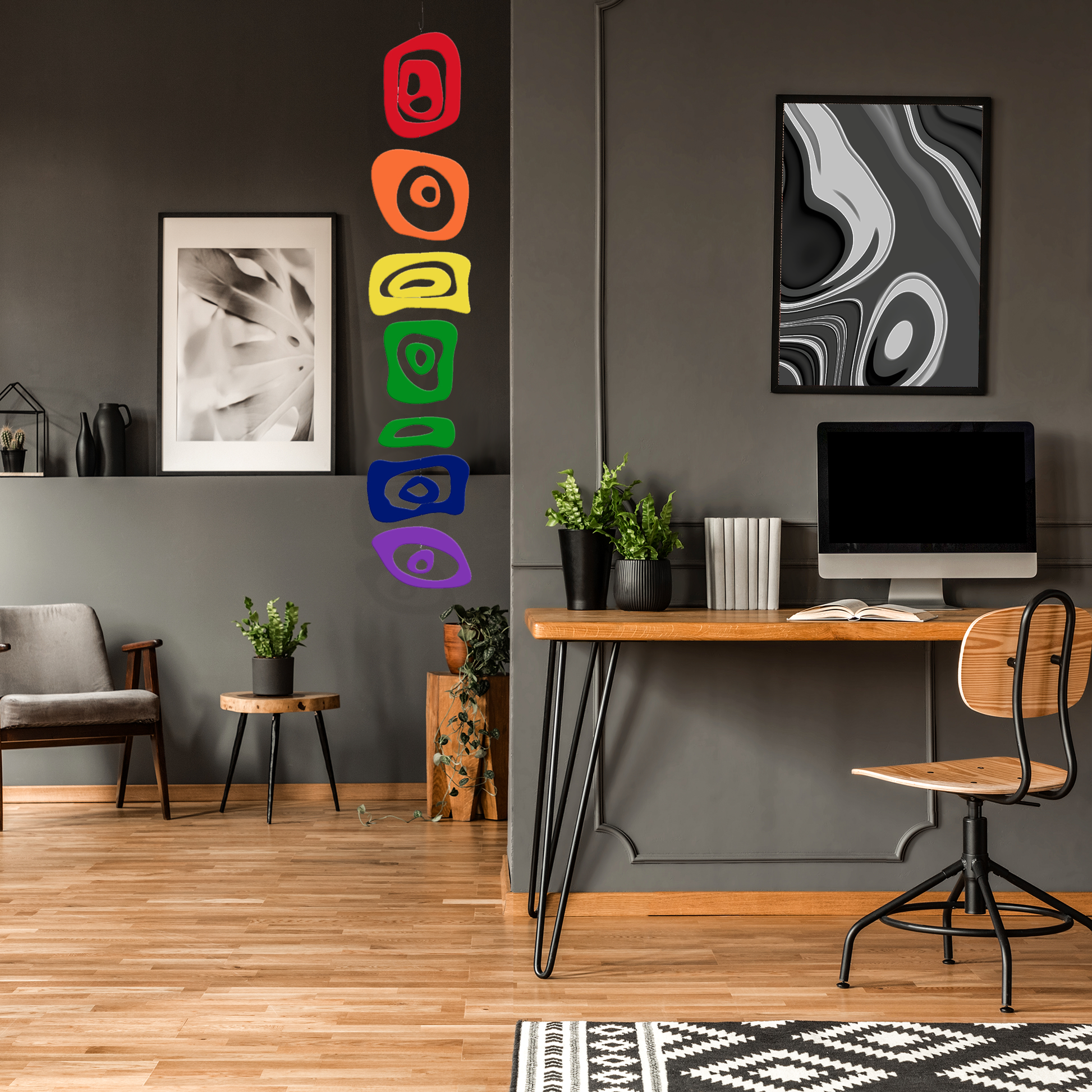 LGBTQ Rainbow Hanging Art Mobile in dark gray room  with plants, home office desk and computer, and abstract art - vertical kinetic art mobile by AtomicMobiles.com