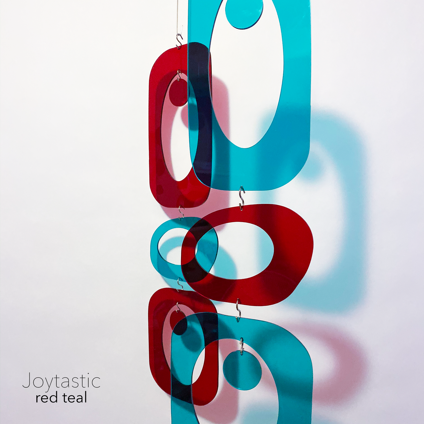 Gorgeous red and teal DIY Atomic Kits in clear color plexiglass casting shadows - hanging art mobiles, curtains, room dividers, screens by AtomicMobiles.com