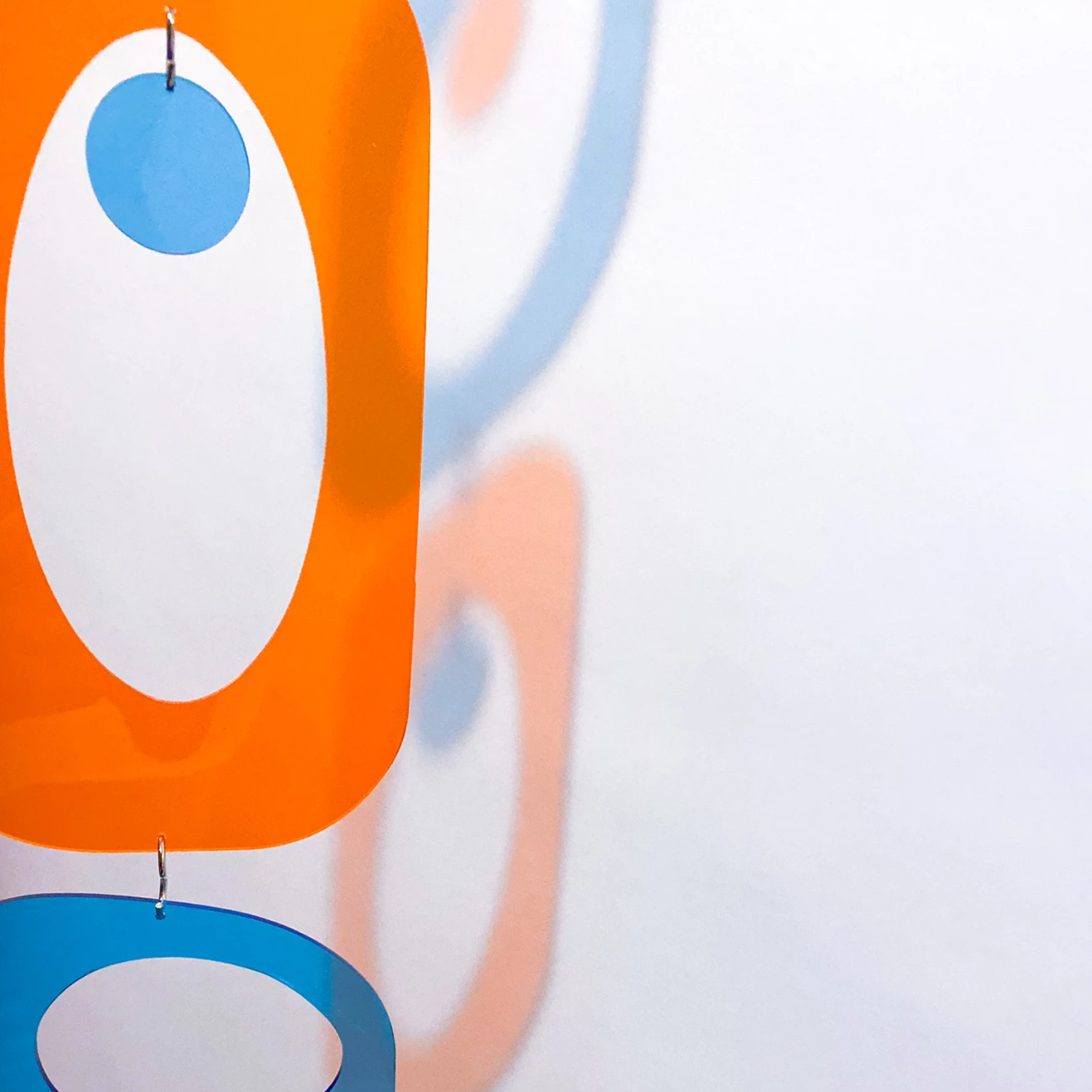 Gorgeous Clear Color Orange and Blue Atomic Kits Parts reflecting against the wall - mid century modern style plexiglass acrylic room dividers and art by AtomicMobiles.com