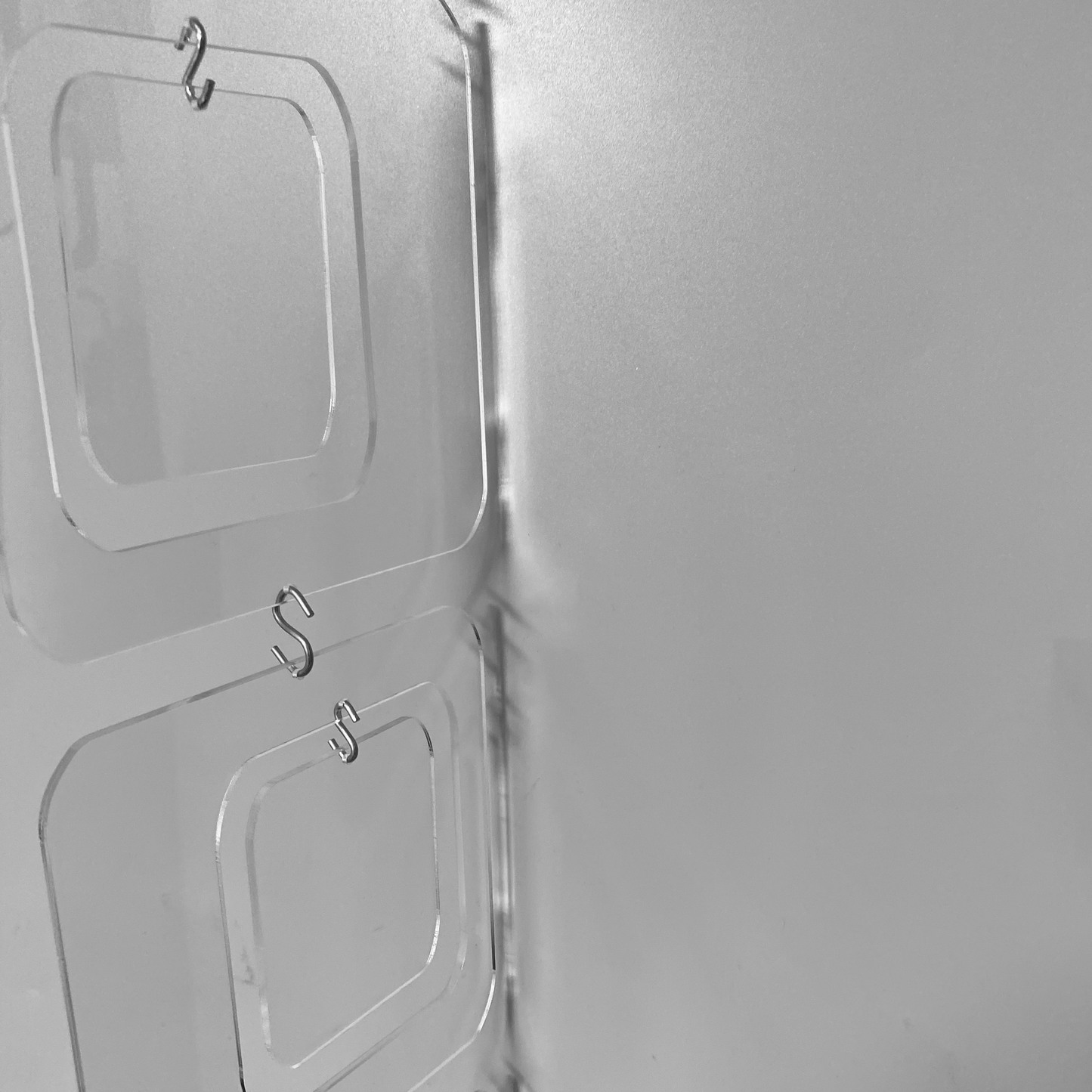 Reflective closeup of Coolsville DIY KIT for mobiles, room dividers, and curtains in Clear Lucite Acrylic by AtomicMobiles.com