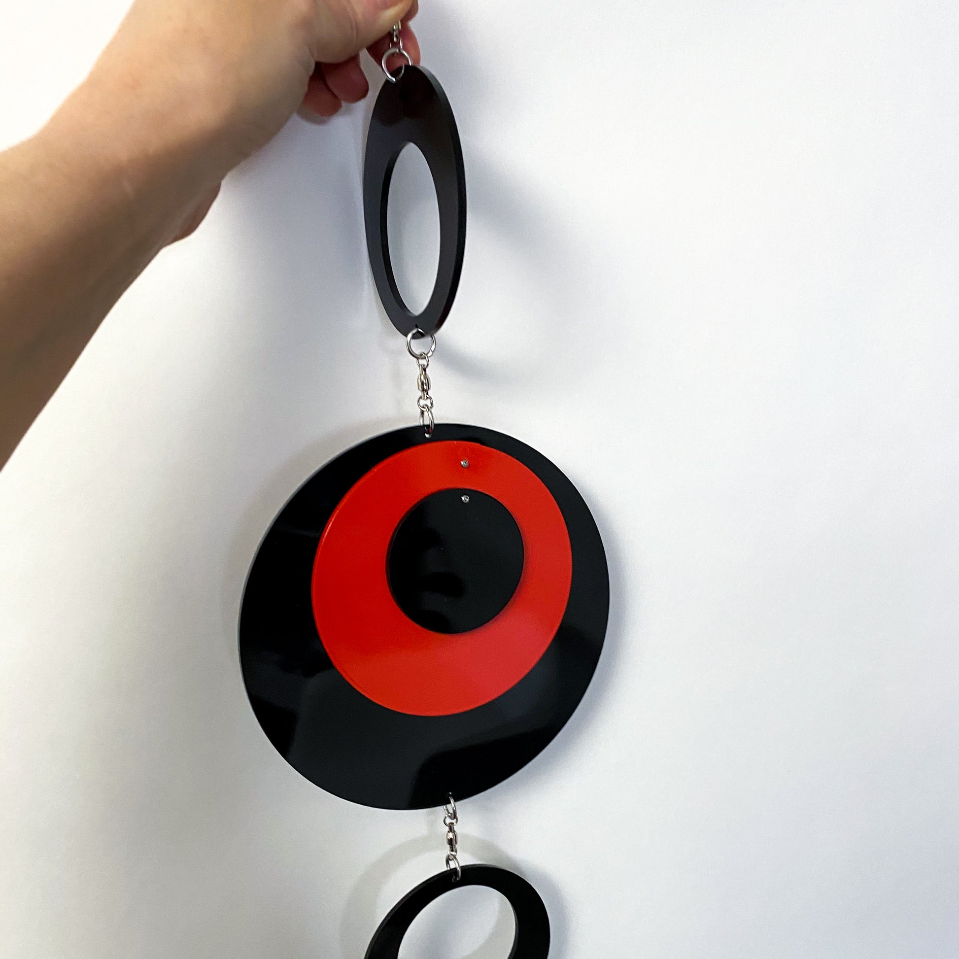 Holding the POPdots in black and red closeup - wall art mobiles by atomicmobiles.com
