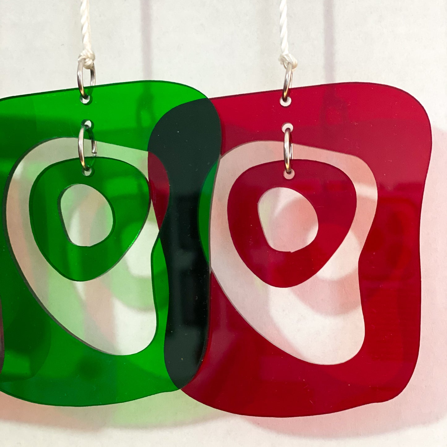 Closeup of gorgeous transparent red and green mid century modern style Christmas Ornaments for your Christmas tree by AtomicMobiles.com