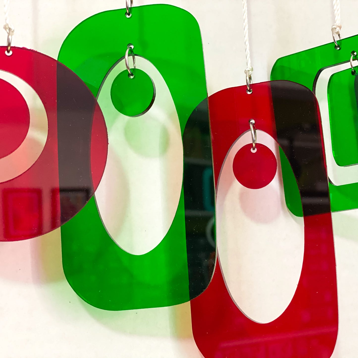 Beautiful closeup of transparent red and green mid century modern style Christmas Ornaments for your Christmas tree by AtomicMobiles.com
