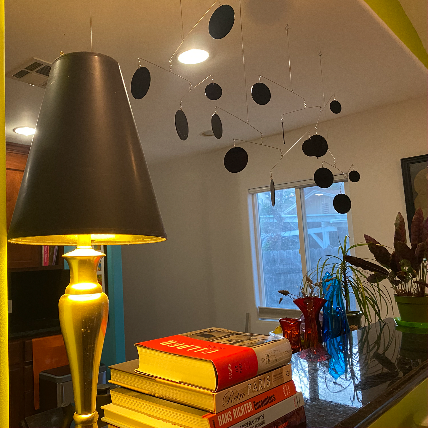 Black Atomic Mobile hanging in modern kitchen with modern art, plants, art books - mobile by AtomicMobiles.com