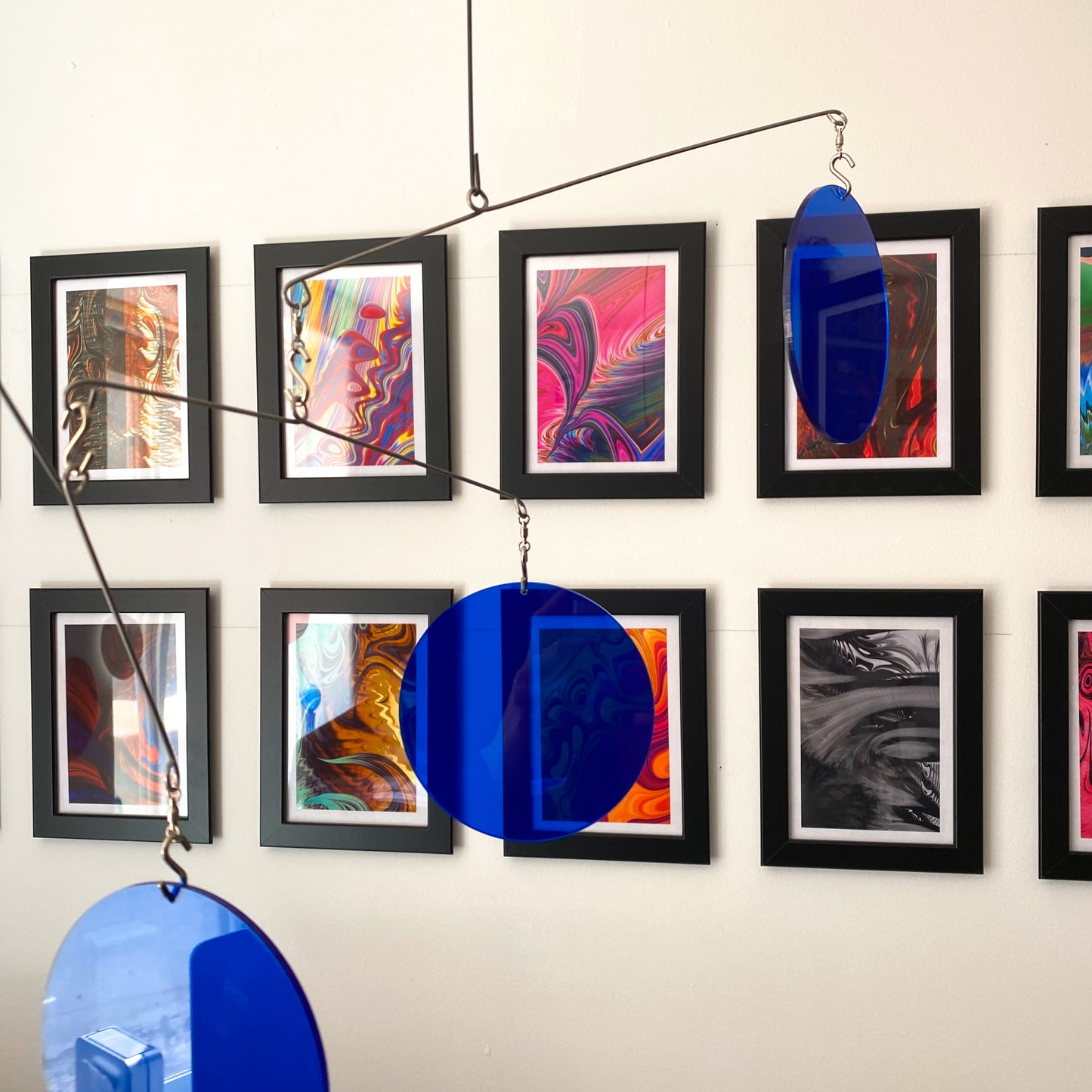 Clear Navy Blue Acrylic Atomic Mobiles in front of MiniMOD abstract art prints by AtomicMobiles.com