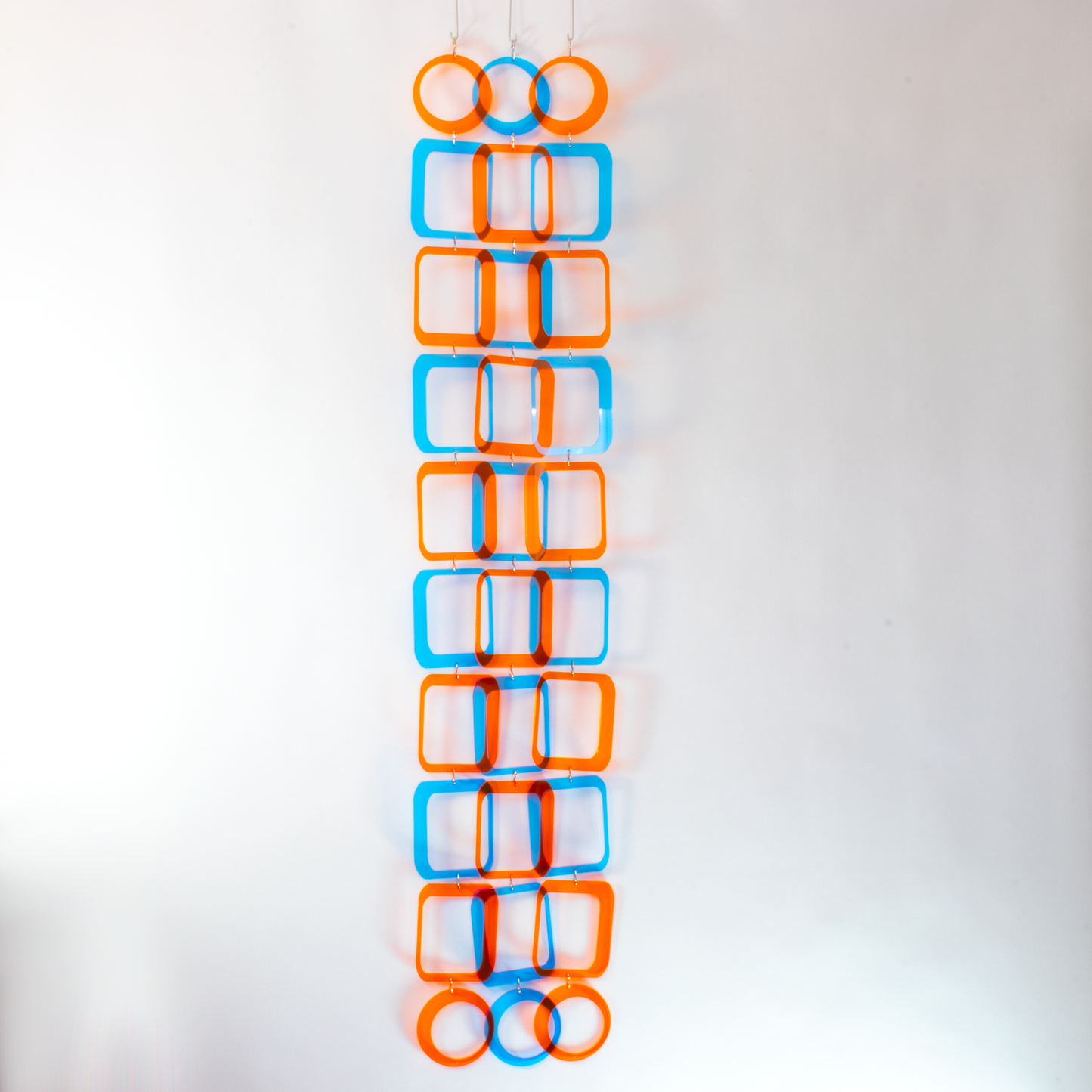 View of Stunning blue and orange clear acrylic retro 1970s room divider, window curtain, wall art, and mobile DIY Kit by AtomicMobiles.com