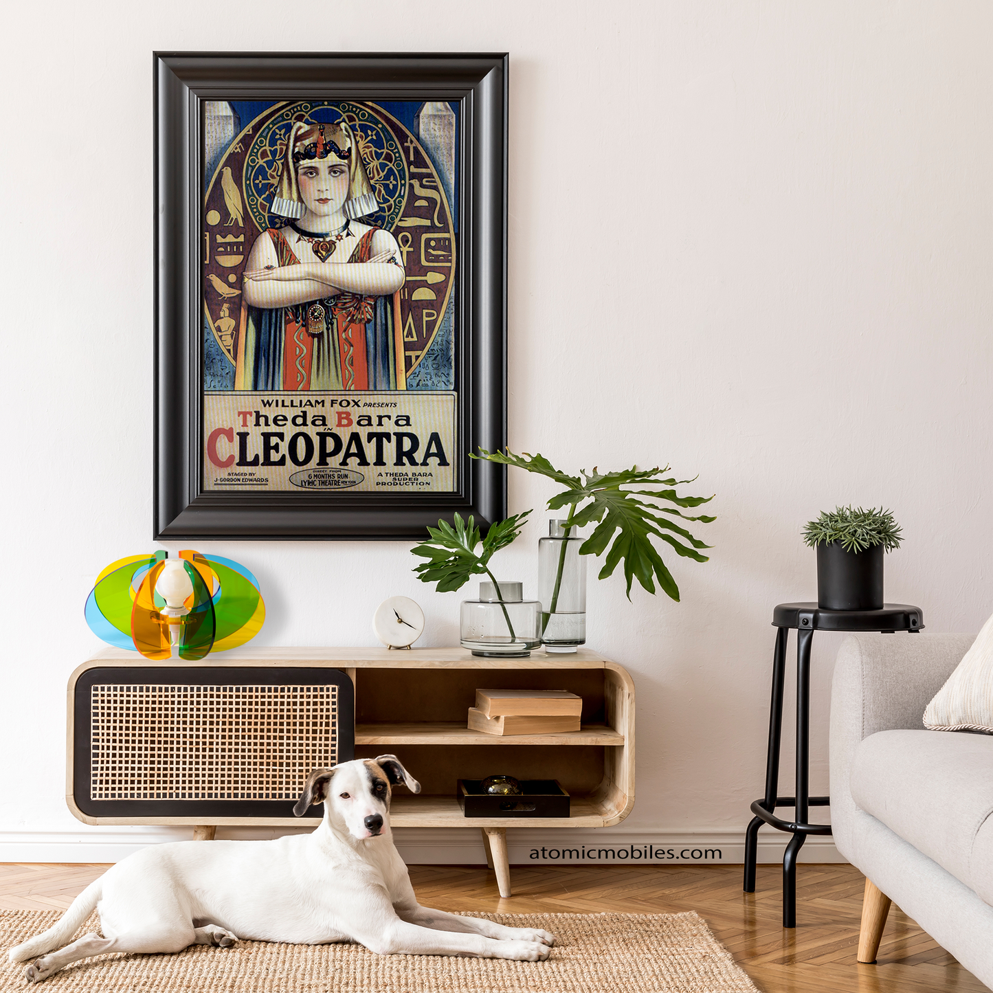ASTROLUMA Space Age Retro Table Top Lamp in clear multi colors acrylic plexiglass plastic with globe light bulb on a mid century modern credenza sideboard furniture and framed Cleopatra poster with plants and cute dog on jute rug on the floor - lamp made in Los Angeles, California USA by AtomicMobiles.com