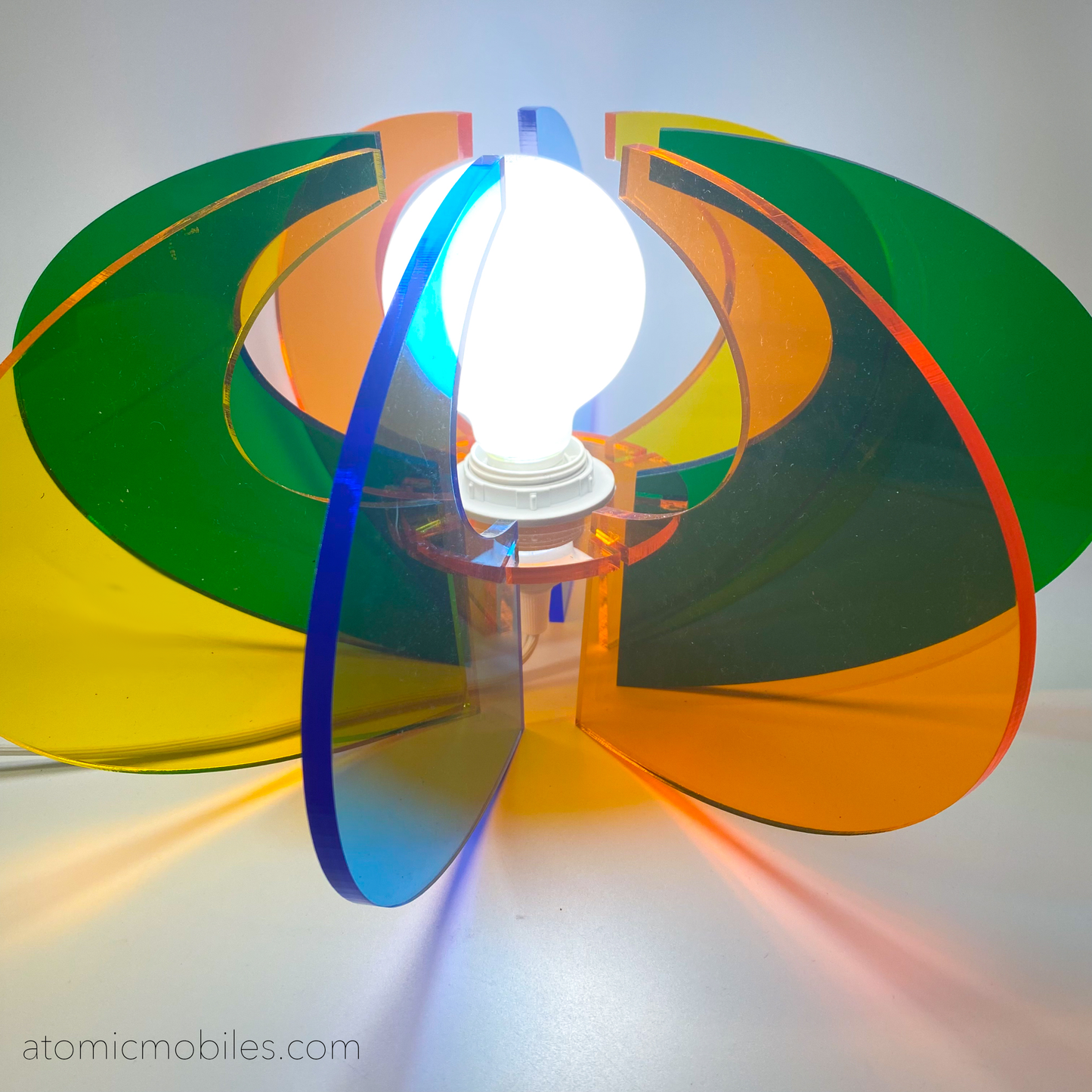 Lit up Orbit Space Age Lamp in clear acrylic colors of orange, blue, yellow, and green- retro mid century modern groovy lighting by AtomicMobiles.com