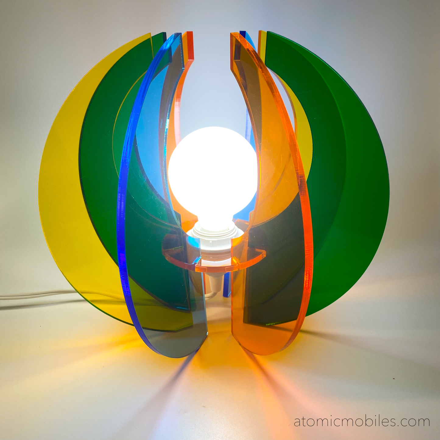Lit up Sphere Space Age Lamp in clear acrylic colors of orange, blue, yellow, and green- retro mid century modern groovy lighting by AtomicMobiles.com