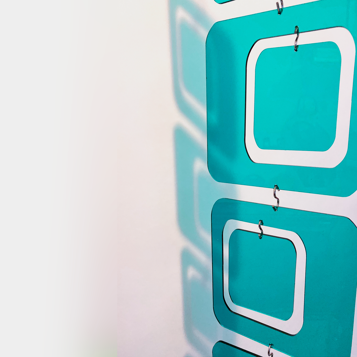 Closeup of clear plexiglass acrylic Teal Coolsville Atomic Kits Parts to make art mobiles, room dividers, and curtains by AtomicMobiles.com