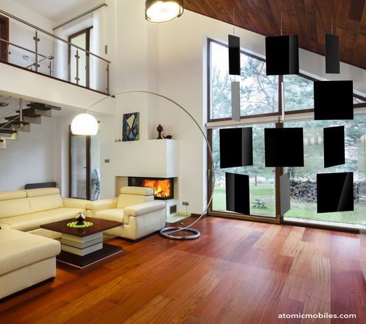 XXL Black MODcast Luxury Art Mobiles shown in modern contemporary home with vaulted ceiling, leather furniture, fireplace, large curved modern lamp and large floor to ceiling windows - mobiles by AtomicMobiles.com