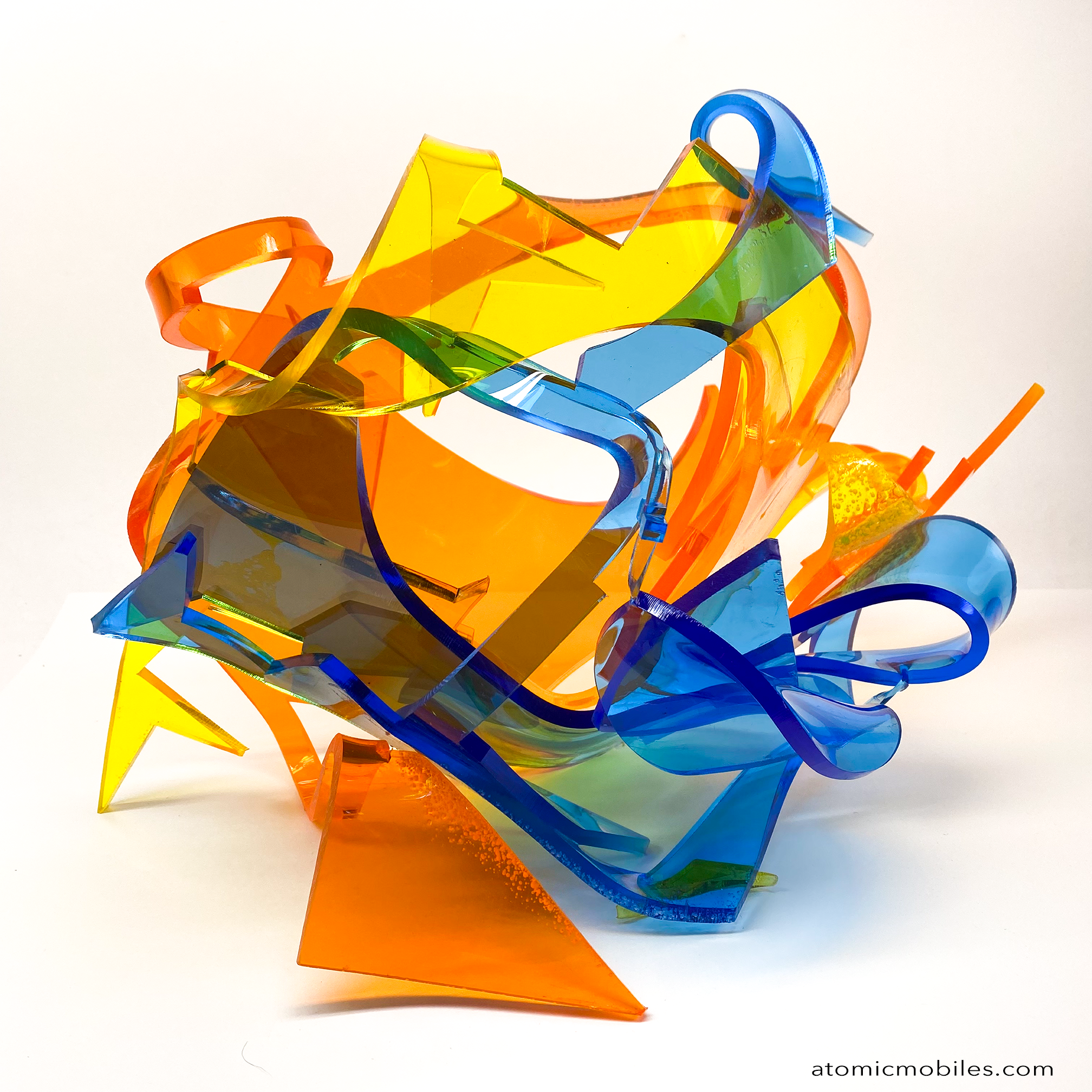 Front view of Dream Abstract Art Sculpture from the Sculptura Collection of incredibly unique art sculptures hand made with earth-friendly upcycled acrylic plexiglass by Debra Ann of AtomicMobiles.com in Los Angeles, featuring bold colors of clear orange, clear blue, and clear yellow