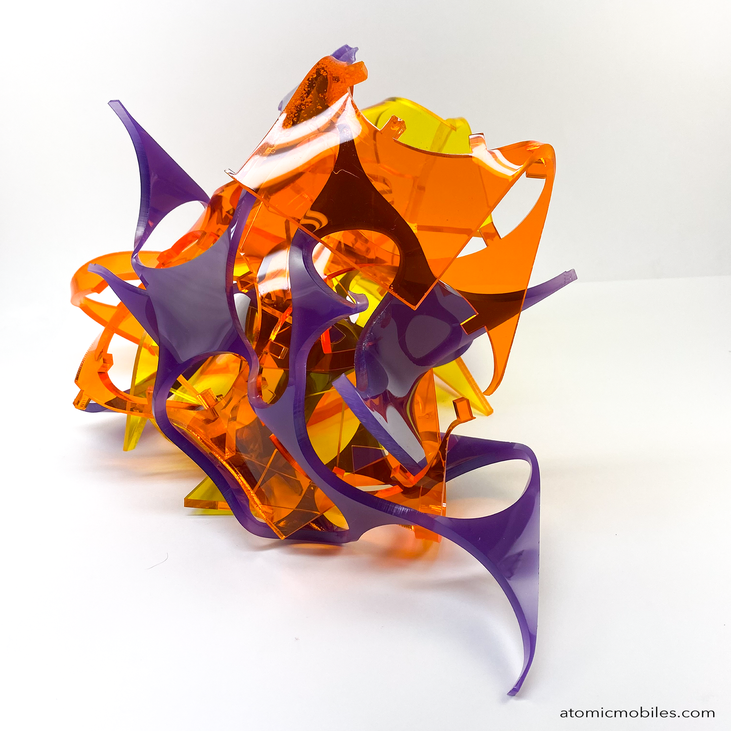 side view of one of a kind Stellar abstract art sculpture in bold clear orange, clear yellow, and opaque purple - made from recycled/upcycled acrylic plexiglass by Debra Ann in Los Angeles of AtomicMobiles.com
