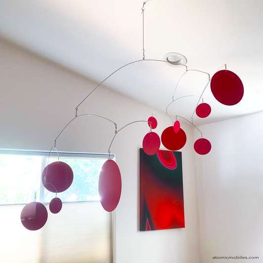 XL Red Kinetic Hangng Art Mobile by AtomicMobiles.com - large red circles in large mobile in dining room over wood table made in Los Angeles