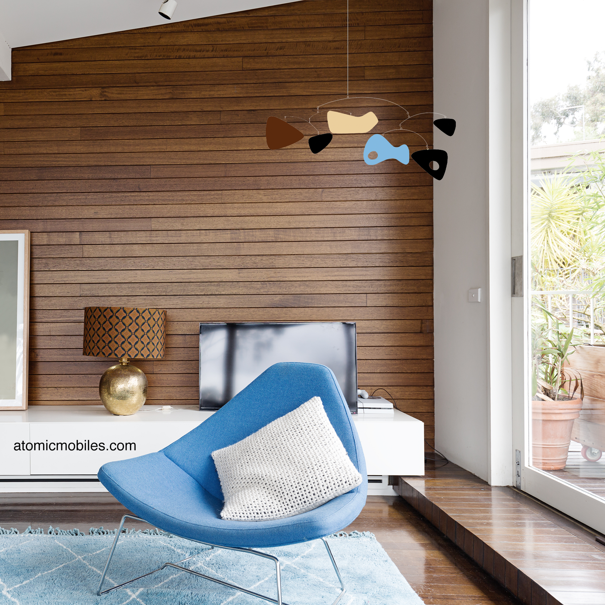 SHAG Art Mobile in modern room with wood paneled wall and blue mid century modern chair - mobile by AtomicMobiles.com -- Shag art interpreted from his Midnight Pool Party artwork with permission