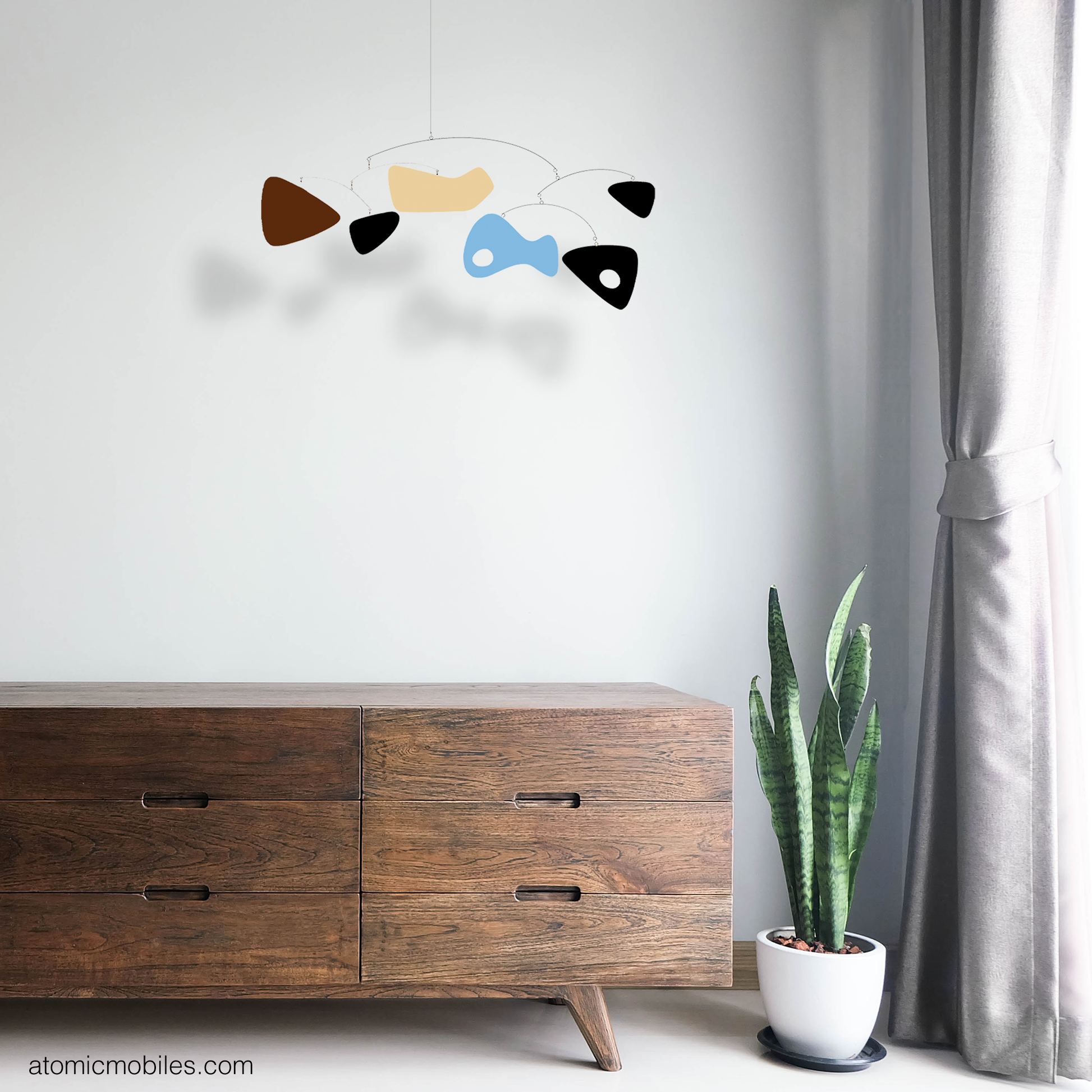 Delightful SHAG Kinetic Art Mobile hanging in corner of room with mid century modern wood credenza, snake plant, and gray drapes - mobile by AtomicMobile.com -- Shag art interpreted from his Midnight Pool Party artwork with permission