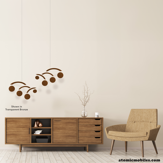 Beautiful mid century modern room with wood credenza, tan color MCM chair, wood floor and transparent bronze hanging art mobiles called The Modernist Mobiles by AtomicMobiles.com