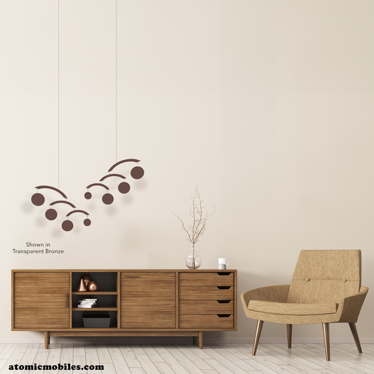 Beautiful mid century modern room with wood credenza, tan color MCM chair, wood floor and transparent bronze hanging art mobiles called The Modernist Mobiles by AtomicMobiles.com