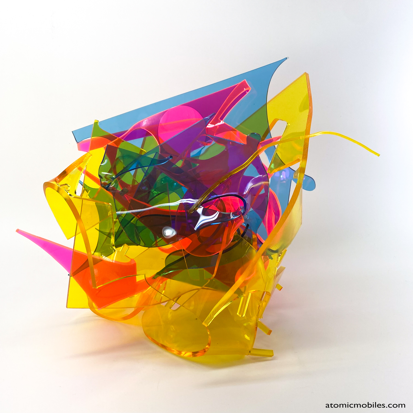 Side view of bold colorful tabletop abstract modern art sculpture stabile in blue, yellow, hot neon pink, orange, and green featuring entangled acrylic plastic by Debra Ann of AtomicMobiles.com