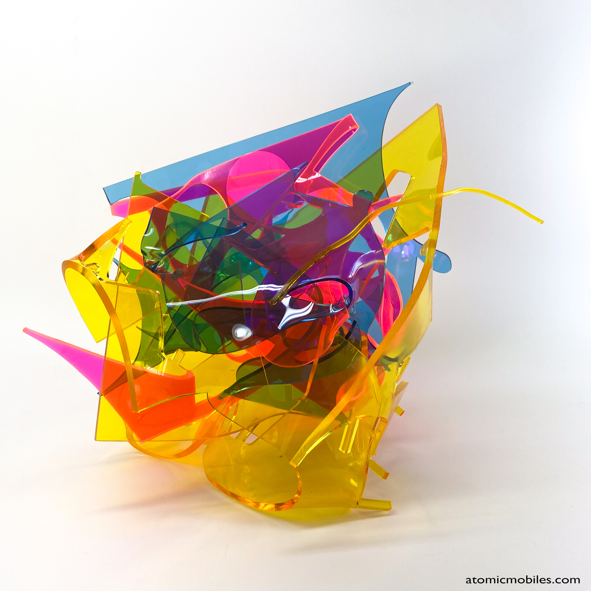 Side view of bold colorful tabletop abstract modern art sculpture stabile in blue, yellow, hot neon pink, orange, and green featuring entangled acrylic plastic by Debra Ann of AtomicMobiles.com