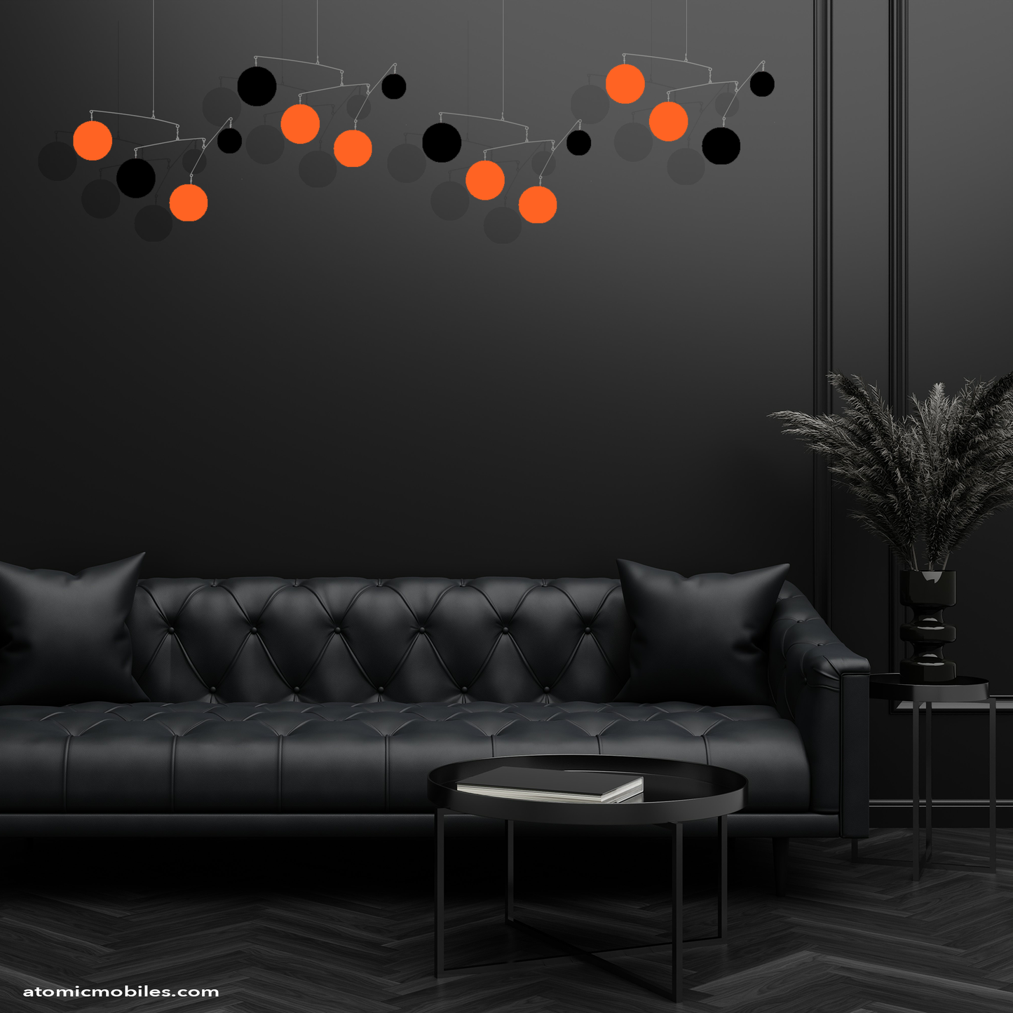 Black room with black sofa, furniture and plant with Halloween themed hanging art mobiles in Orange and Black by AtomicMobiles.com