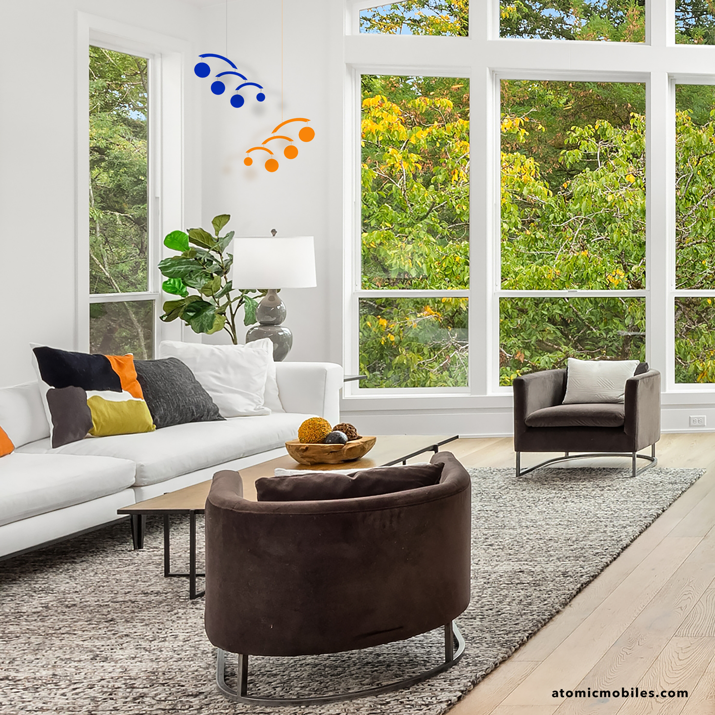 Beautiful modern living room with white walls, contemporary furniture and The Modernist Mobiles in Navy Blue and Orange hanging in the corner of the room - modern kinetic hanging art mobiles by AtomicMobiles.com
