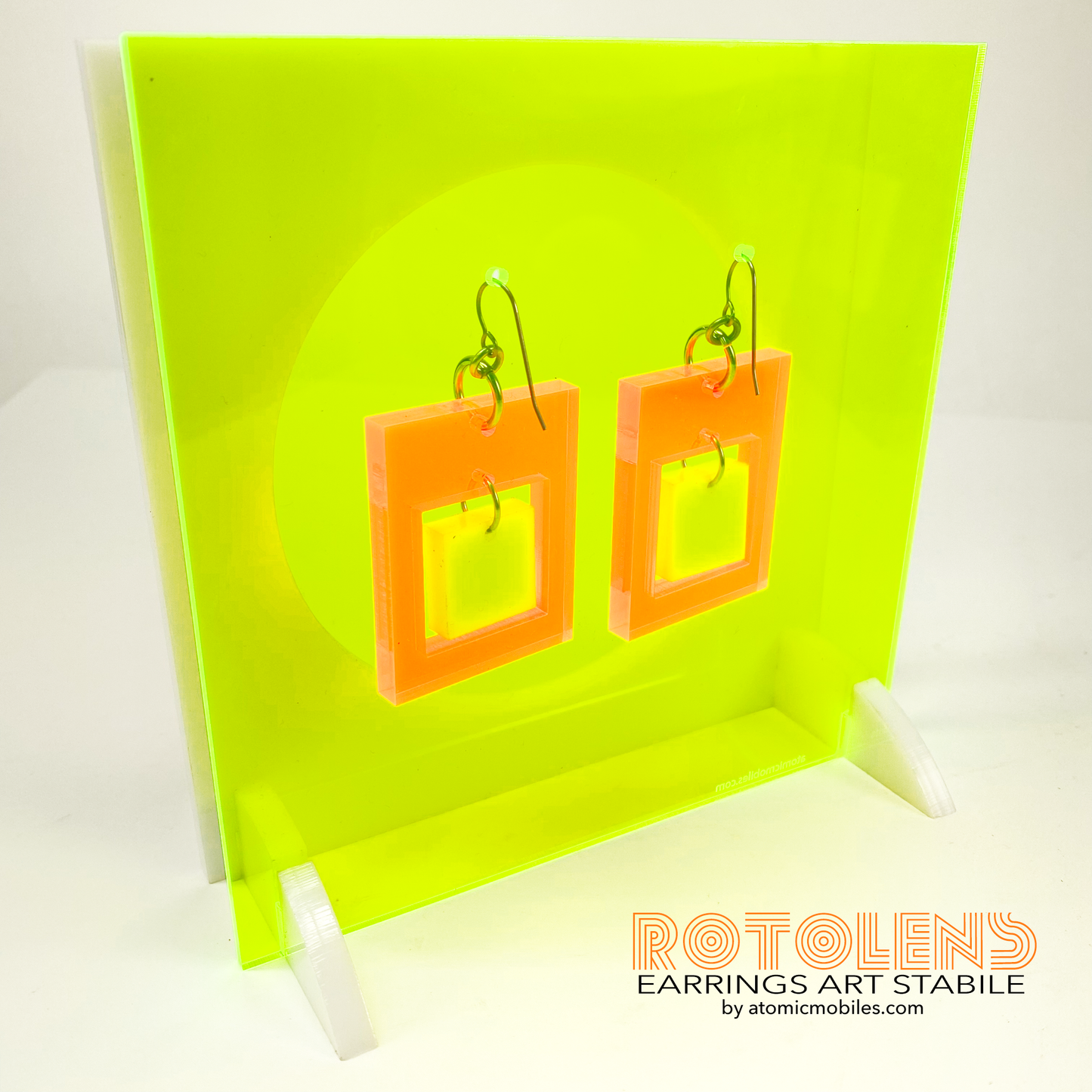 Back view of Stunning Art Earrings Stabile Set featuring transparent neon green backing with orange and white earrings - mid century modern art for Groovy People by AtomicMobiles.com