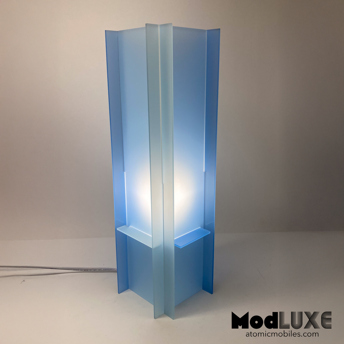 Stunningly beautiful baby blue table lamp in space age modern style with reversible color  - with the light switched on - by AtomicMobiles.com