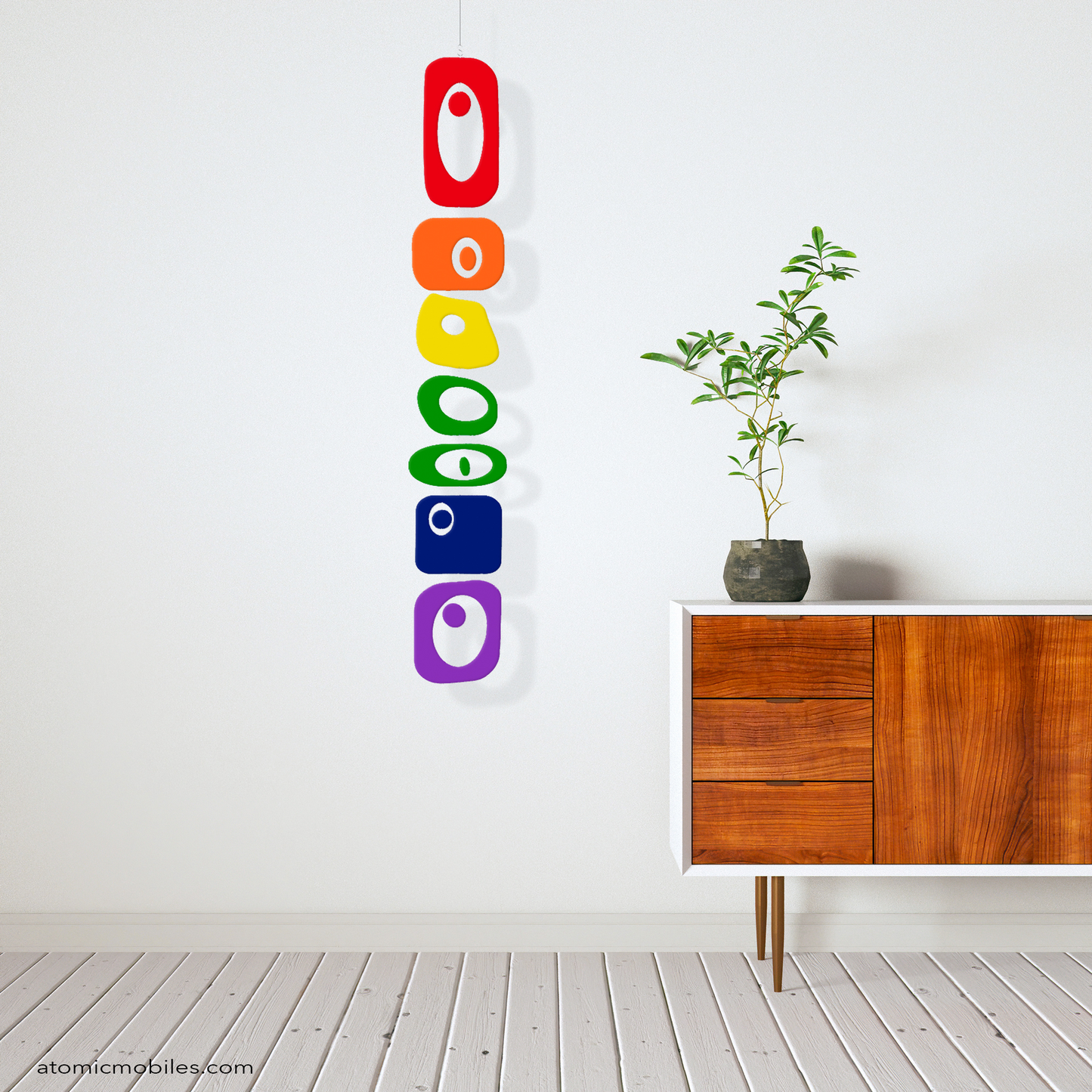 LGBTQ+ Rainbow Pride BEATNIK PARTY hanging art mobile in rainbow colors in mid century modern zen room with wood credenza, plant, and wood slat floor - mobile by AtomicMobiles.com