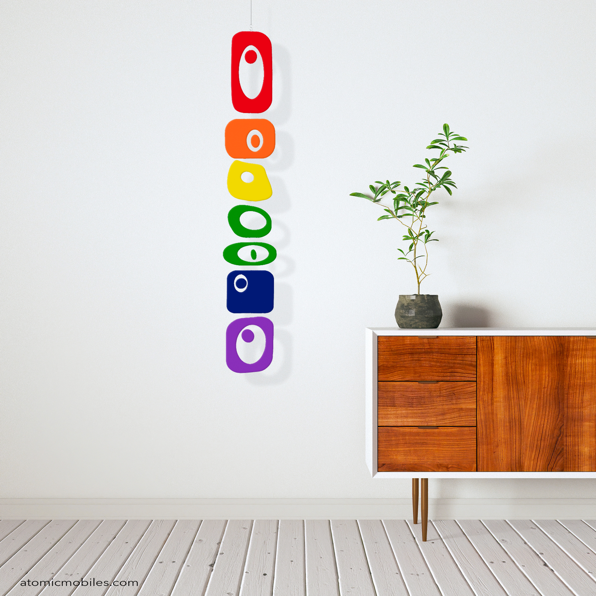 LGBTQ+ Rainbow Pride BEATNIK PARTY hanging art mobile in rainbow colors in mid century modern zen room with wood credenza, plant, and wood slat floor - mobile by AtomicMobiles.com