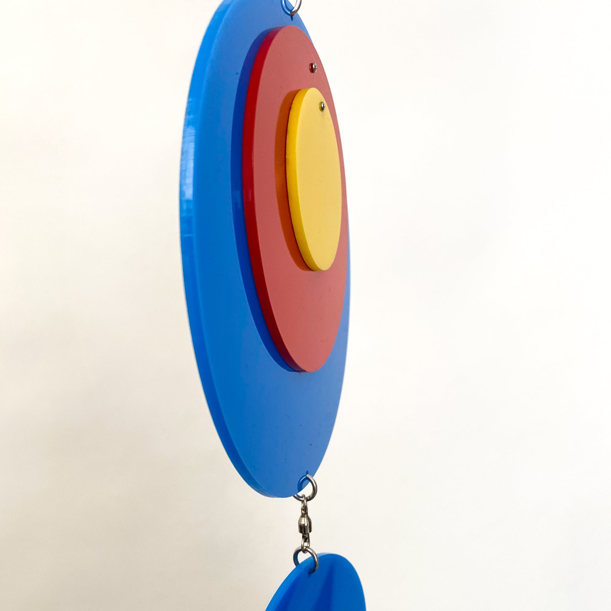 Side view of Groovy Twirly Blue Multi Color Vertical Kinetic Mobile in Blue Red and Yellow by AtomicMobiles.com