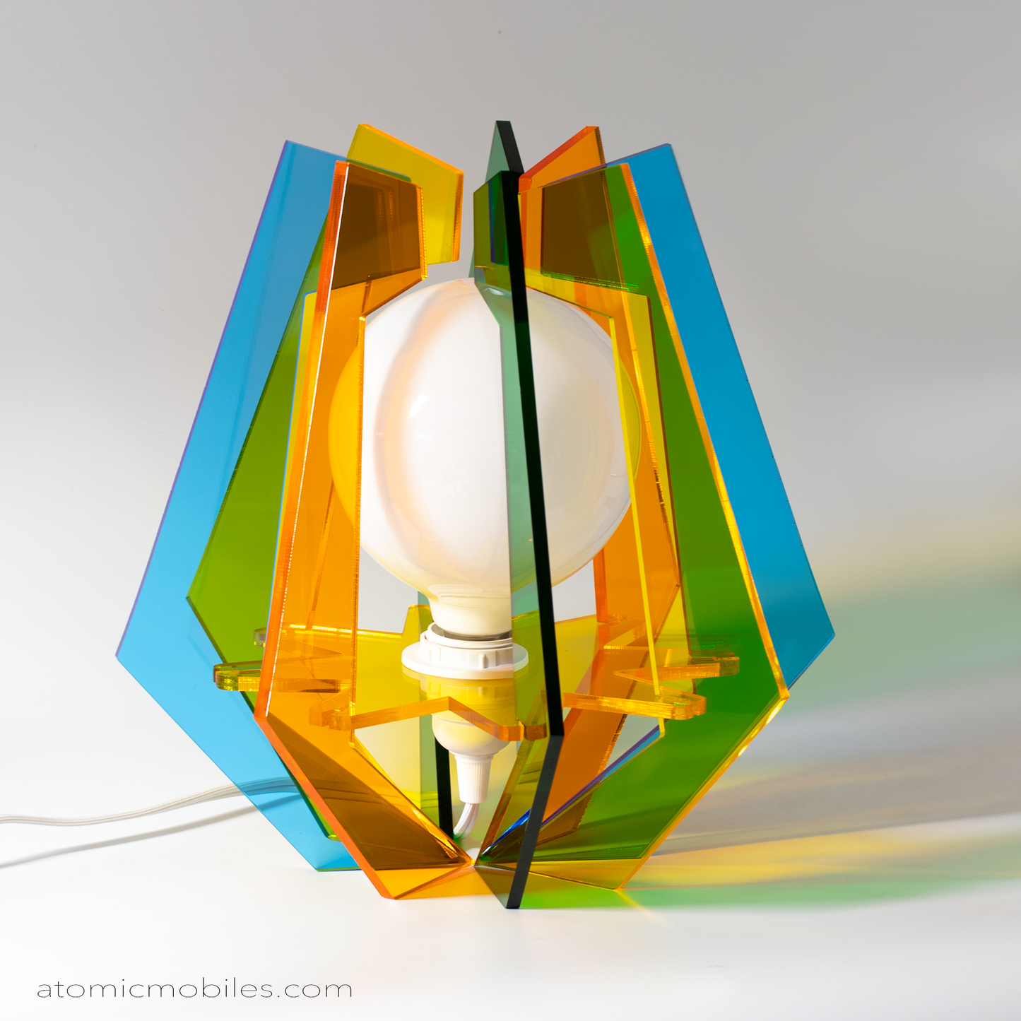 Unique retro mid century modern style table top lamp in clear orange, green, yellow, and blue plexiglass acrylic made in Los Angeles by AtomicMobiles.com