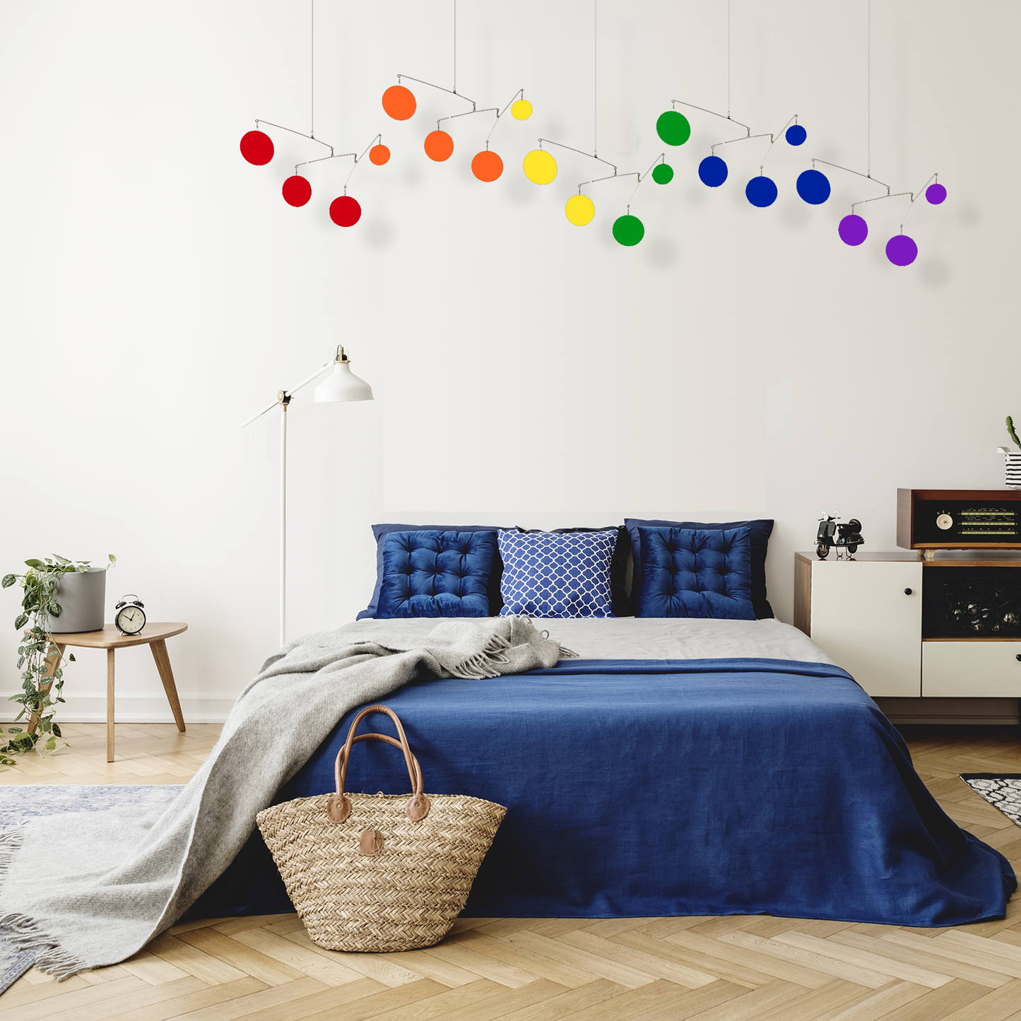 The Atomic Mobile in bedroom with navy blue comforter and pillows with wood floor - Exclusive Rainbow Pride LGBTQ+ Colors by AtomicMobiles.com - Love is Love