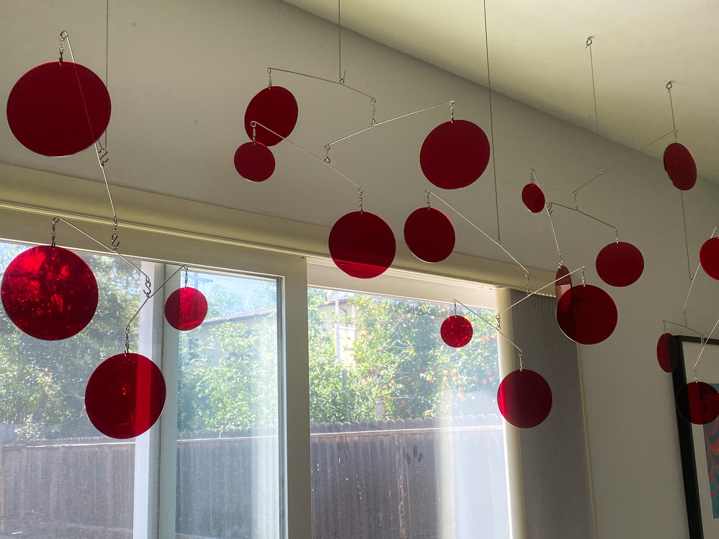 Clear Red Reflective Atomic Mobiles in bedroom overlooking trees in backyard by AtomicMobiles.com