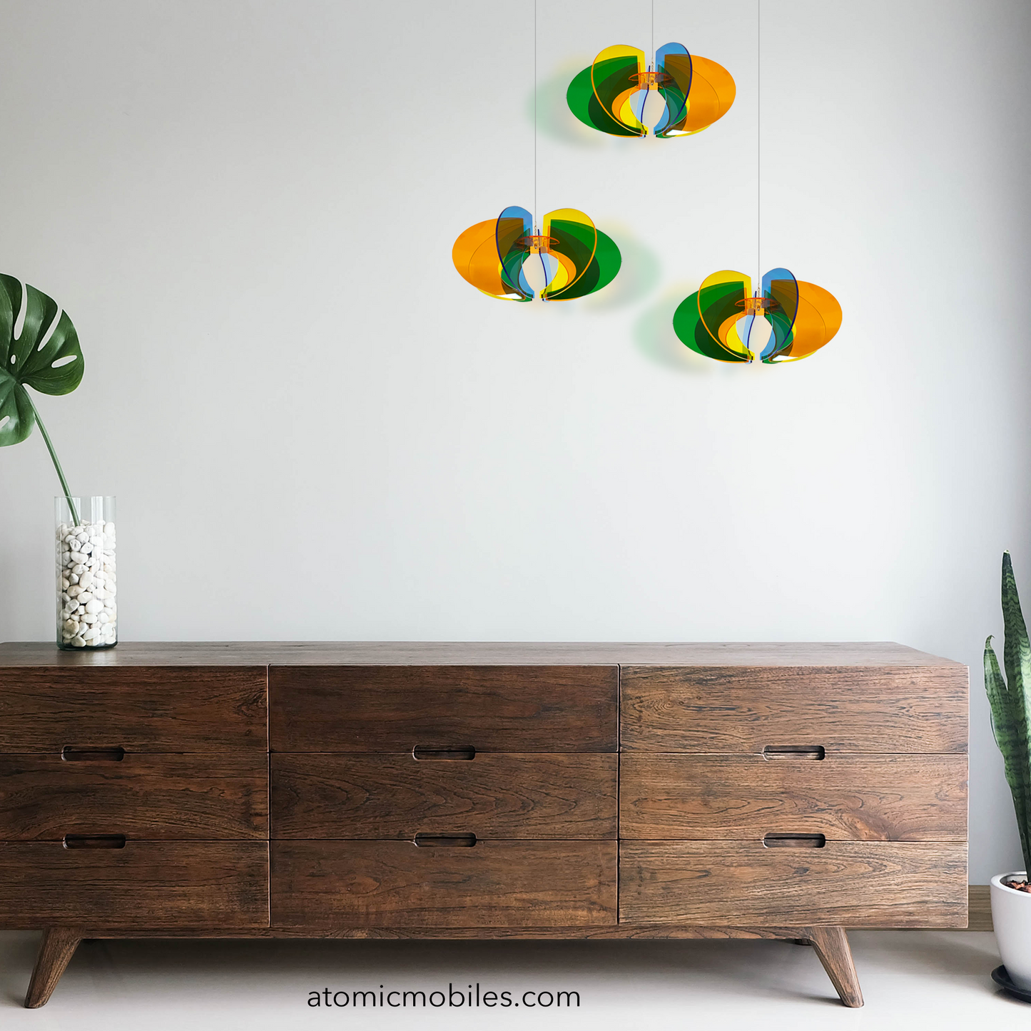 3 Orbit Rotamobiles in mid century modern room with wood credenza sideboard and plants - kinetic hanging art mobiles by AtomicMobiles.com