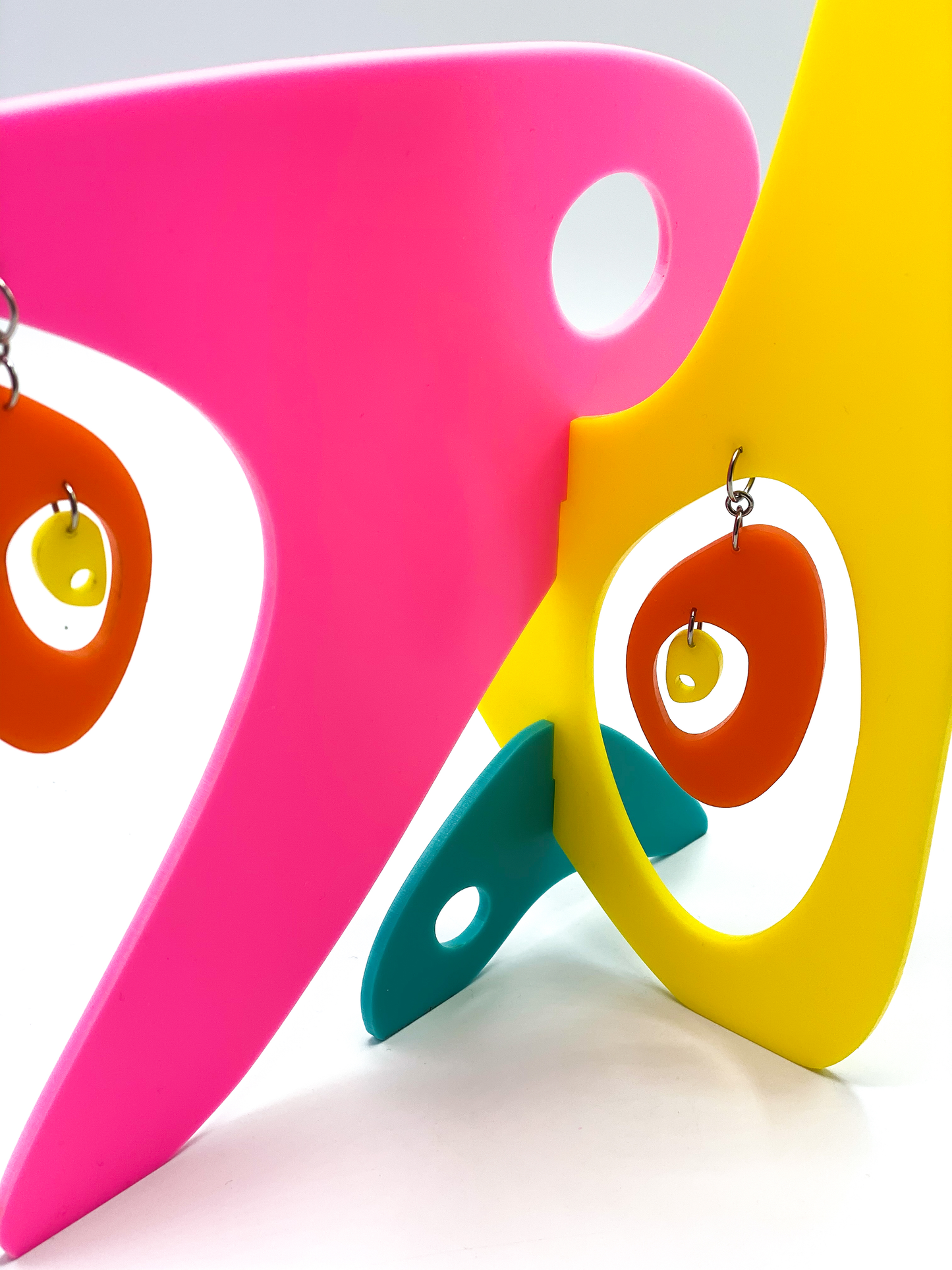 Closeup of Hot Pink Yellow Aqua and Orange Beatnik Boho earrings + sculpture by AtomicMobiles.com