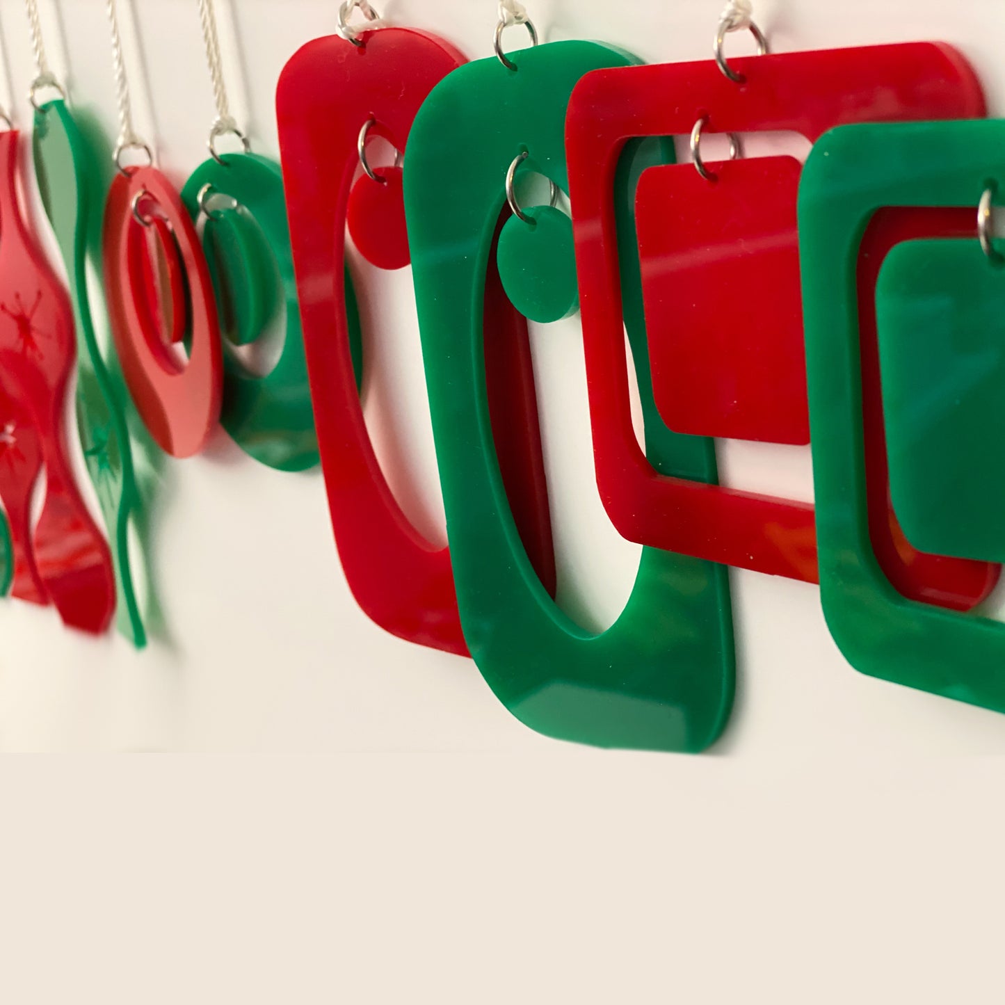 Side view of unique mid century modern style Christmas Ornaments in red and green by AtomicMobiles.com