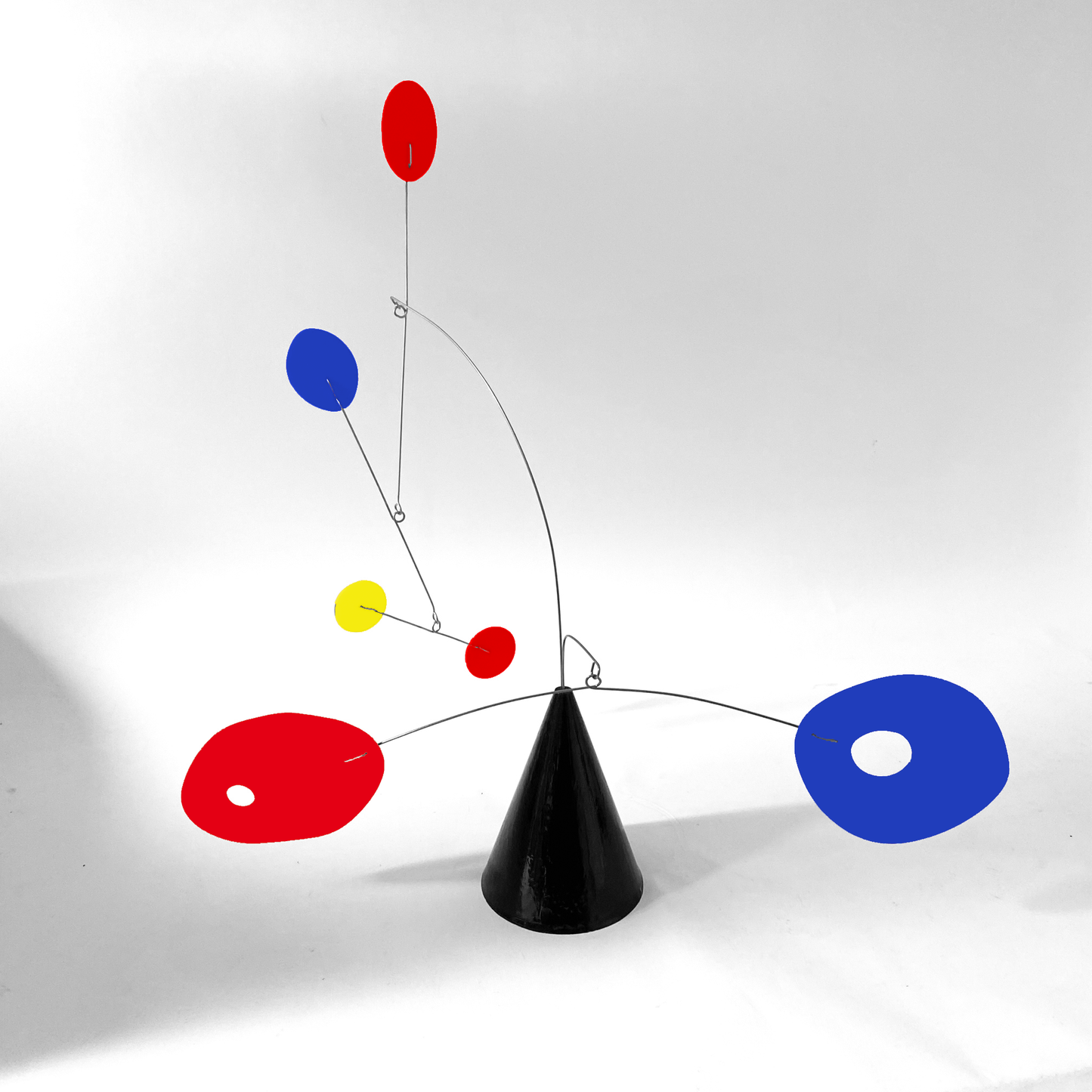 The Strobile table top kinetic art sculpture in multi colors of Red, Blue, Yellow, and Black by AtomicMobiles.com