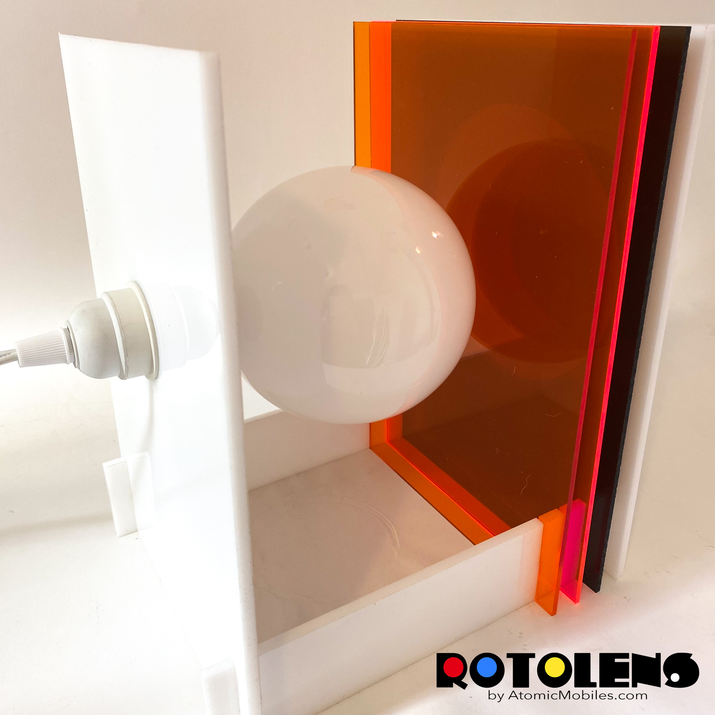 Back view of ROTOLENS Space Age Lamp with interchangeable clear plexiglass lens in Clear Orange, Fluorescent Pink, and Smoky Gray by AtomicMobiles.com
